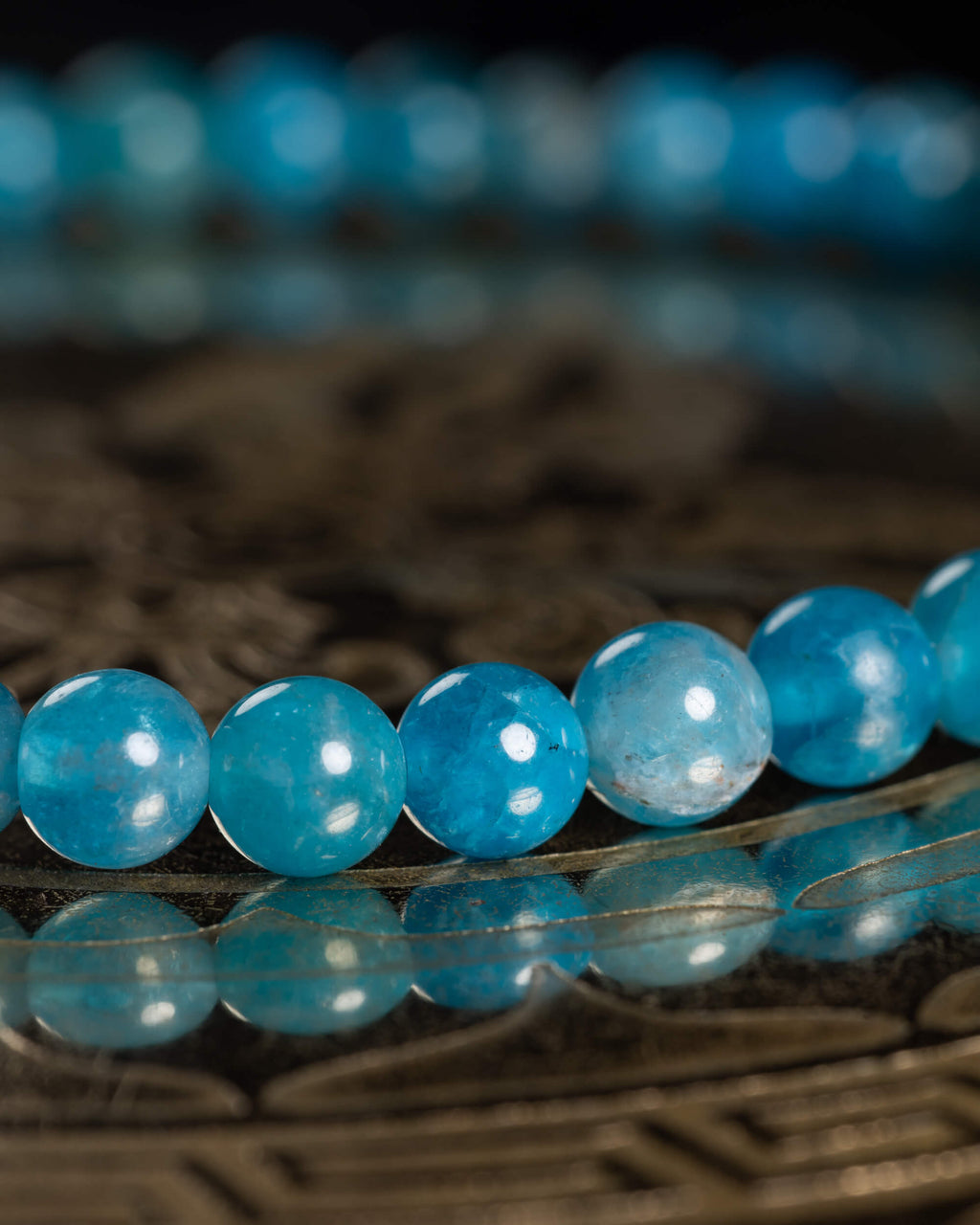 Detalle macro de las cuentas de Apatita Azul con reflejos de luz