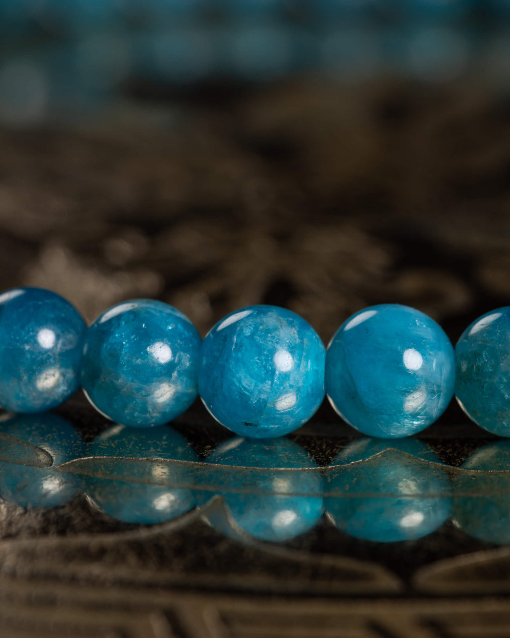 Detalle macro de cinco cuentas de Apatita Azul con textura translúcida