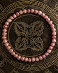 Pulsera de Rodonita Rosa de 4 mm, pieza completa sobre bandeja metálica grabada