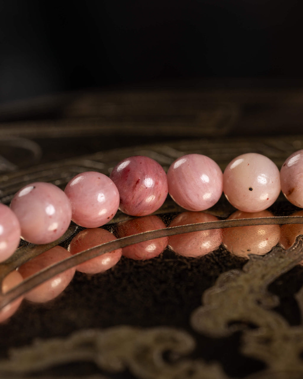 Detalle macro de cuentas de Rodonita en tonos rosa y una cuenta rosa intenso