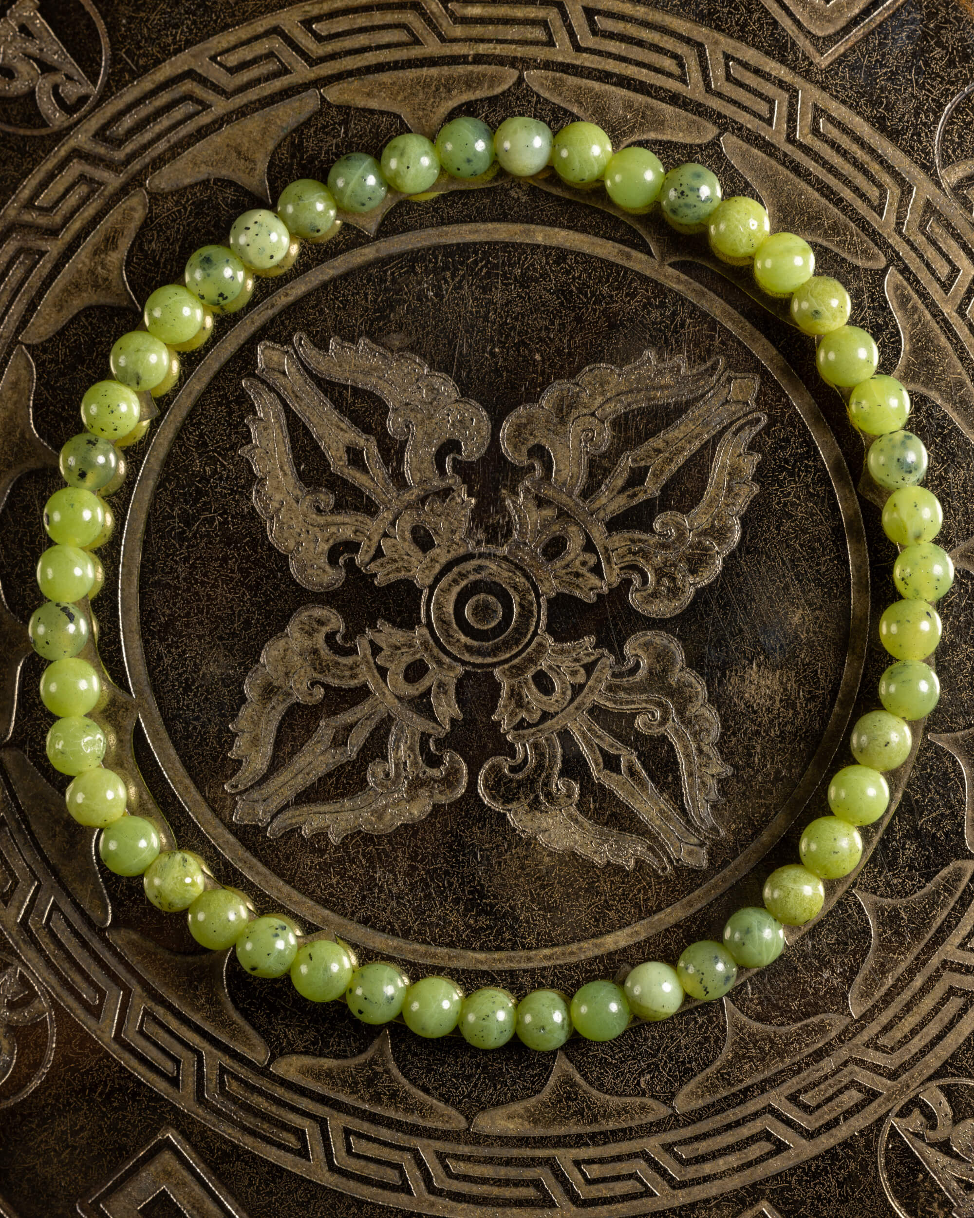 Pulsera de Jade Verde de 4 mm, pieza completa en círculo sobre placa metálica grabada