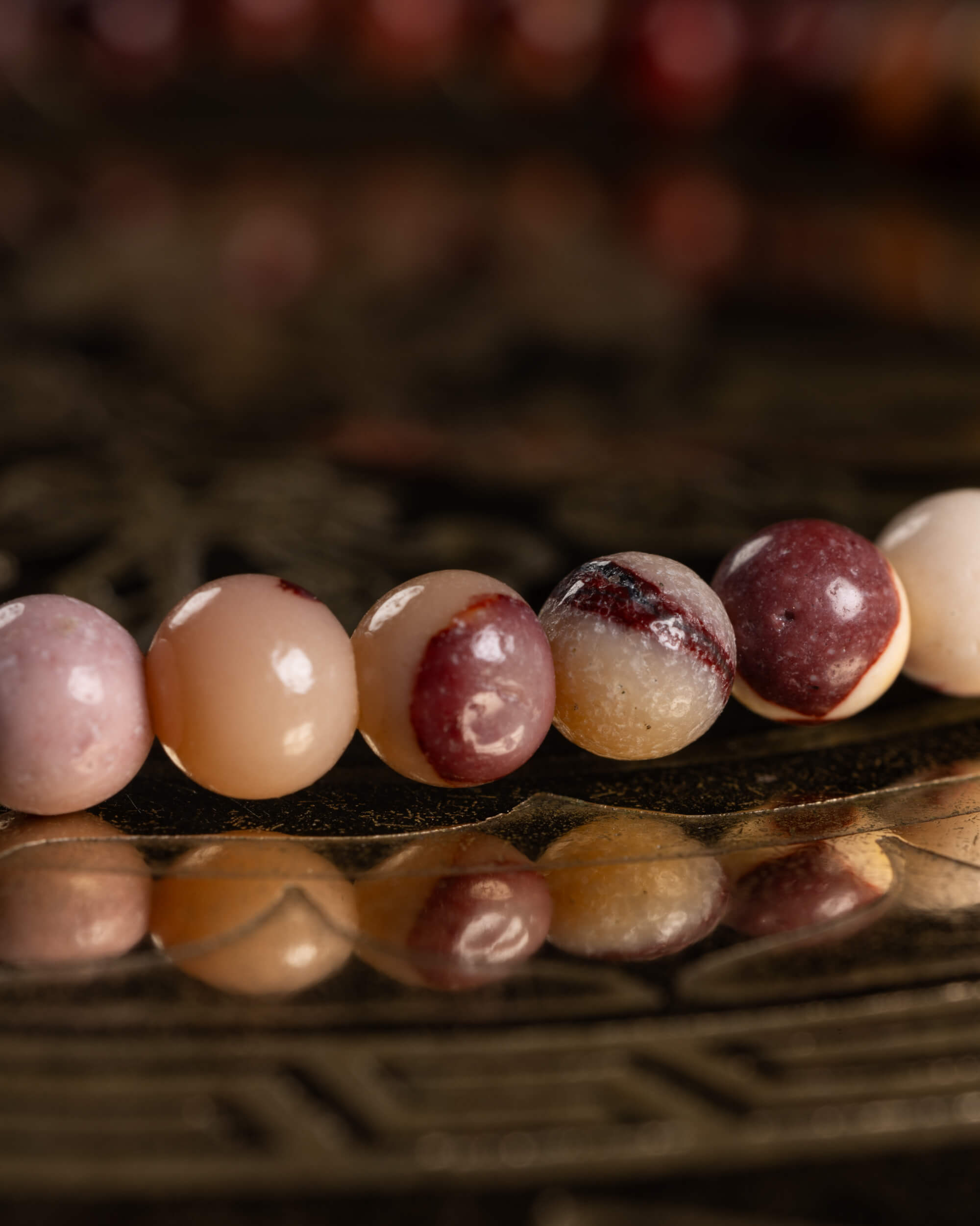 Detalle macro de las cuentas de Jaspe Mokaita en tonos rosa, crema y vino