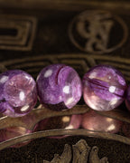 Detalle macro de cuatro cuentas de Lepidolita Violeta con brillo y vetas