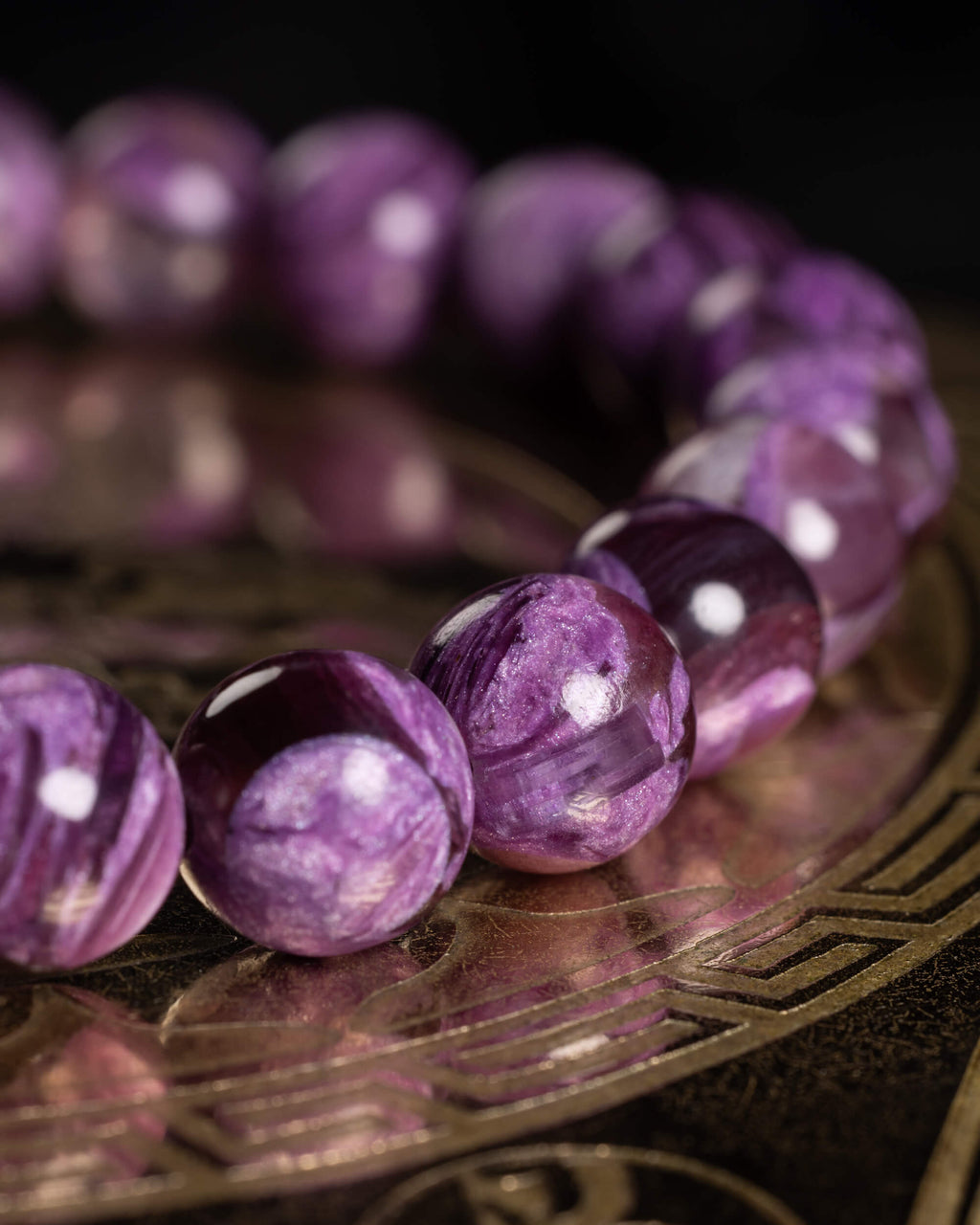 Pulsera de Lepidolita Violeta en fila, cuentas moradas iluminadas sobre bandeja