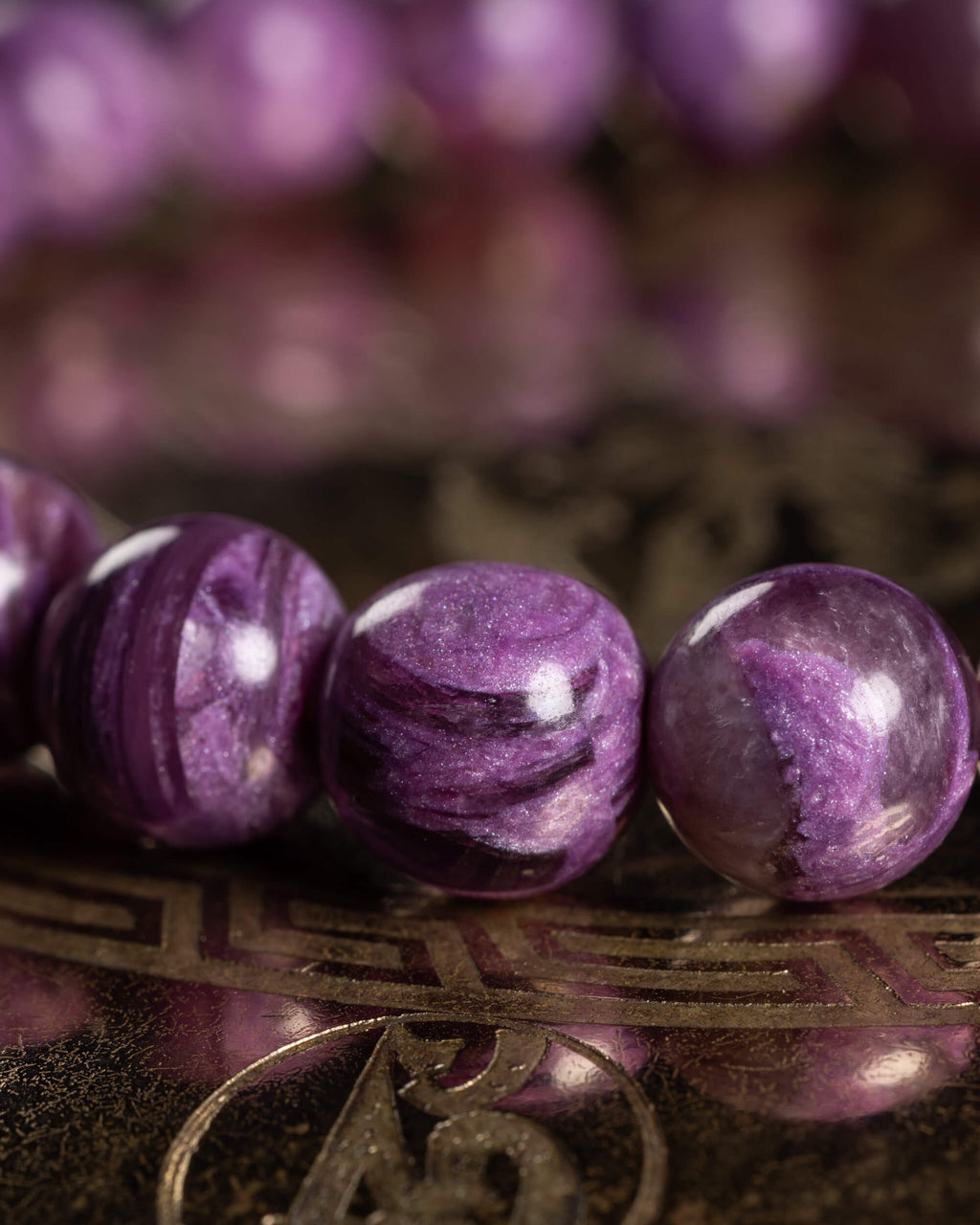 Detalle macro de cuentas de Lepidolita Violeta con vetas oscuras y brillo