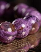 Detalle macro de las cuentas violeta de Lepidolita con vetas moradas