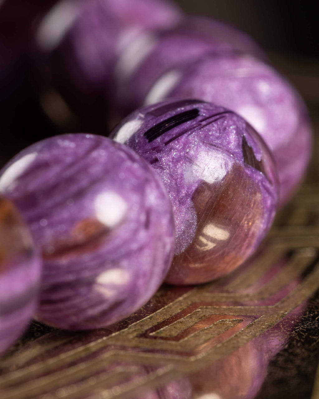 Detalle macro de dos cuentas de Lepidolita Violeta con textura veteada