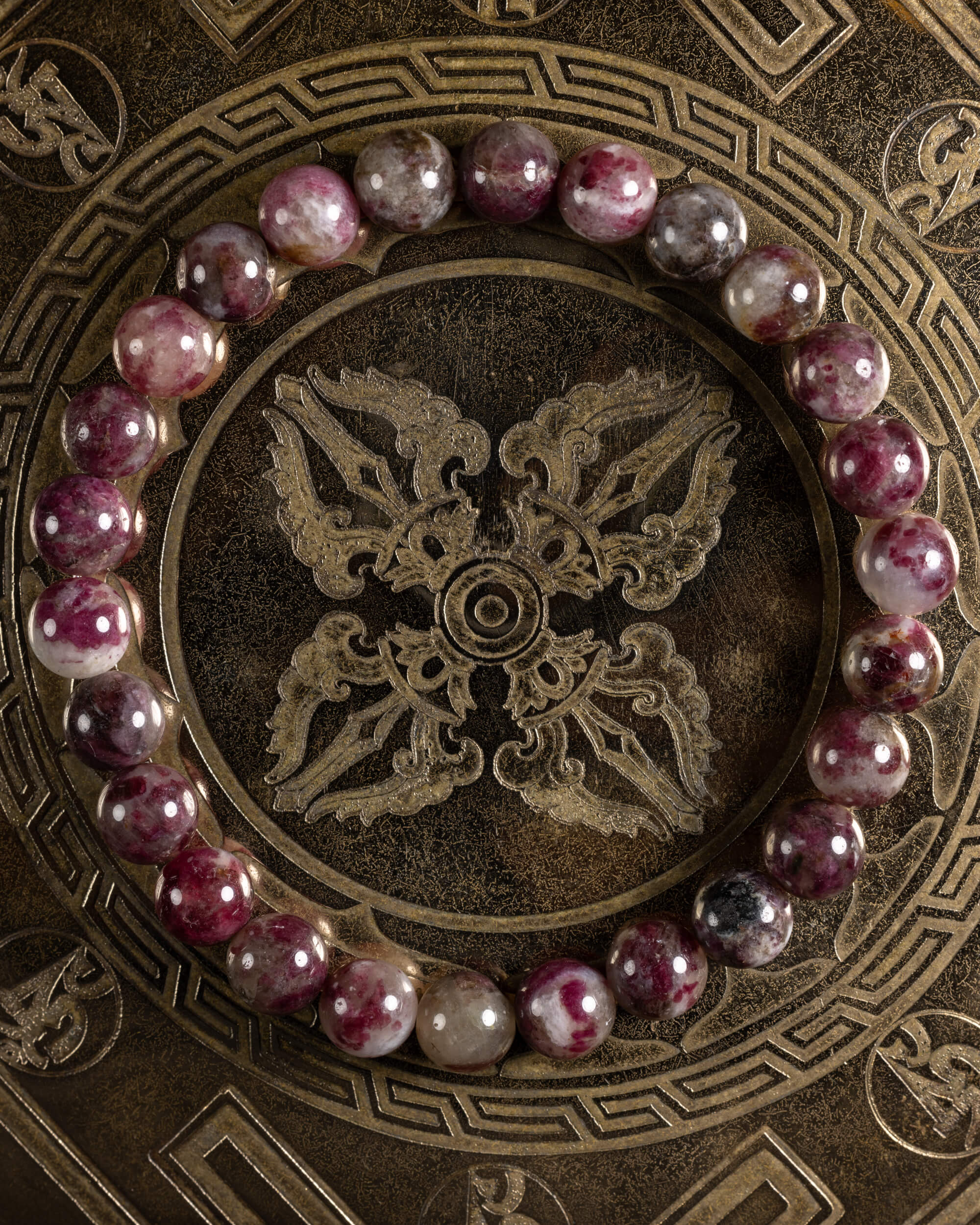Pulsera de Turmalina Rubelita de 8 mm, pieza completa en círculo sobre plato grabado