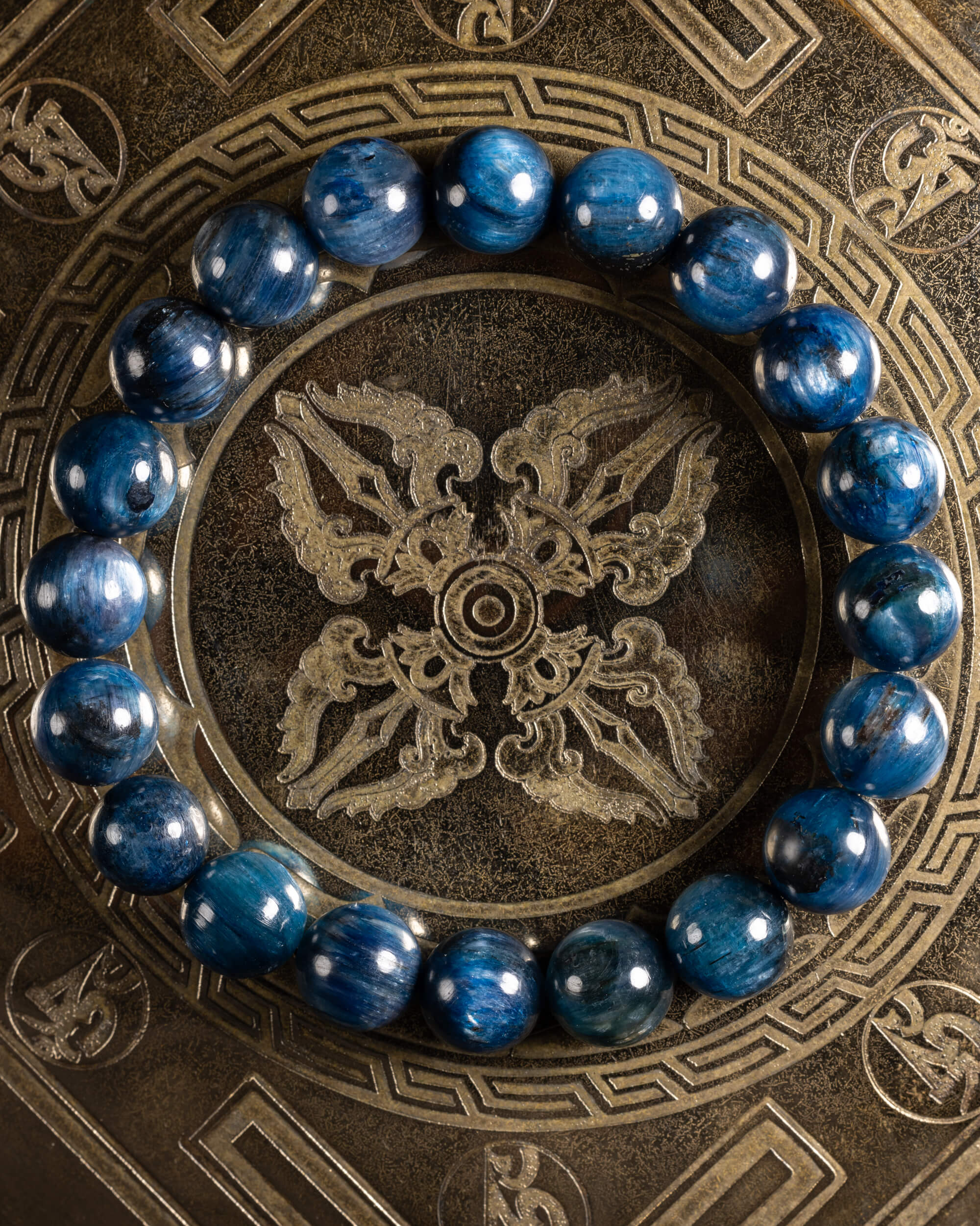 Pulsera de Cianita Azul de 10 mm, pieza completa con textura fibrosa sobre soporte grabado