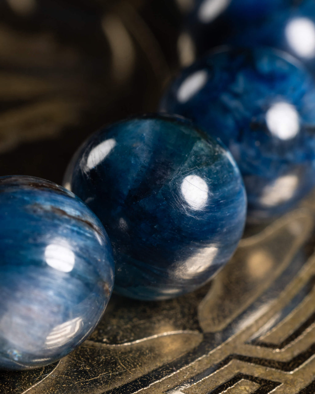Detalle macro de cuentas de Cianita Azul con veteado y reflejos de luz
