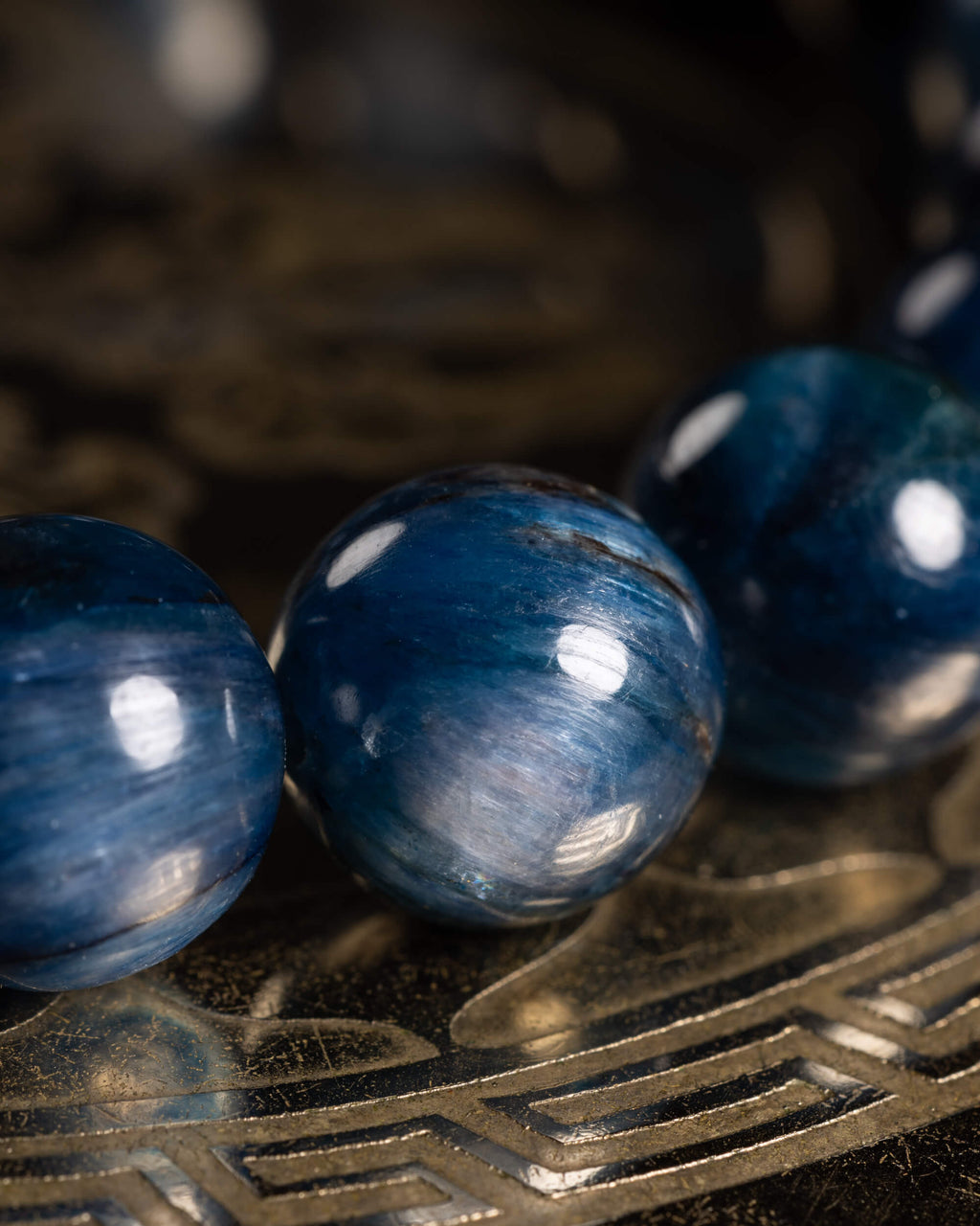 Detalle macro de tres cuentas de Cianita Azul con brillo satinado