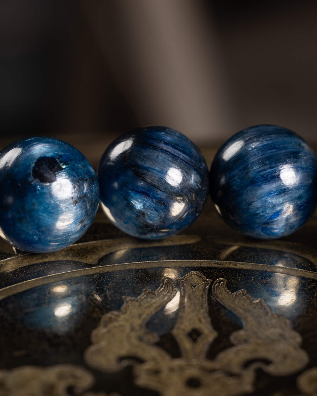 Detalle macro de cuentas de Cianita Azul, una con inclusión oscura visible
