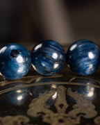 Detalle macro de cuentas de Cianita Azul, una con inclusión oscura visible