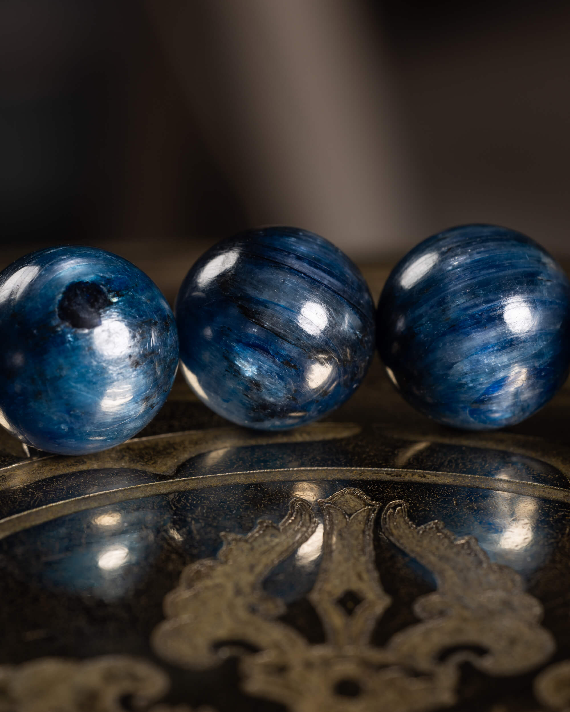 Detalle macro de cuentas de Cianita Azul, una con inclusión oscura visible