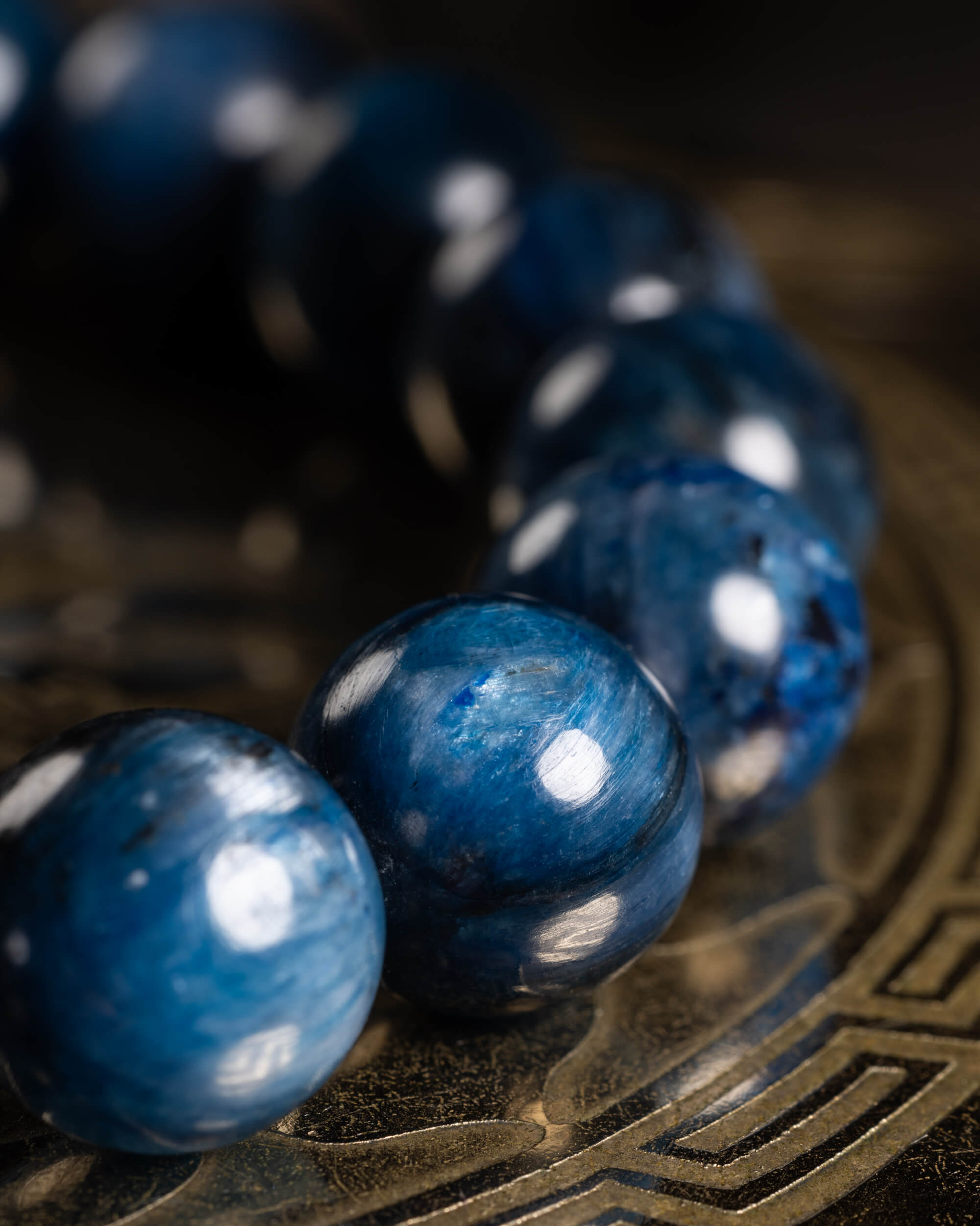 Pulsera de Cianita Azul en fila, cuentas azules con reflejo sobre metal grabado