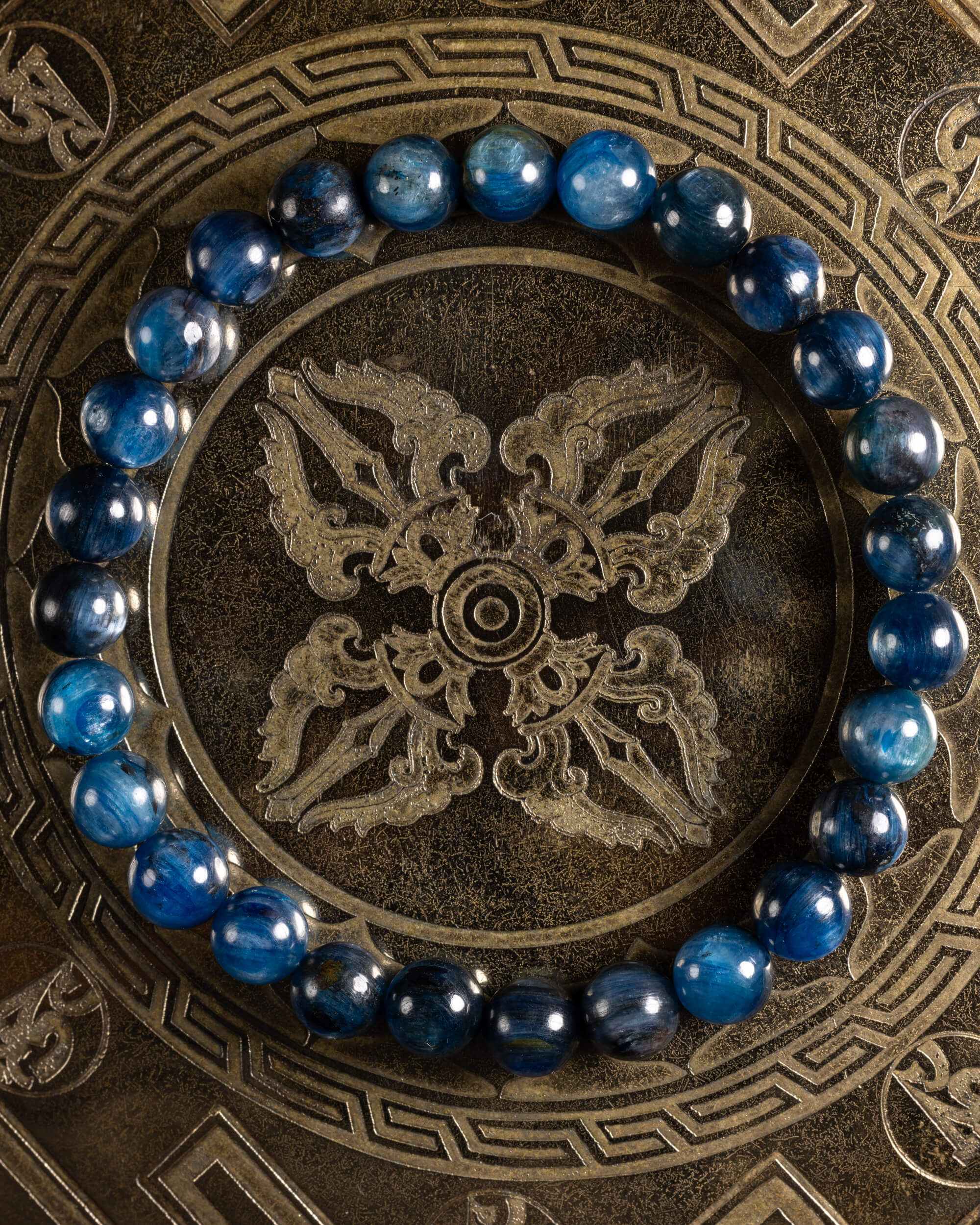 Pulsera de Cianita Azul de 7 mm, pieza completa sobre disco grabado con motivos dorados