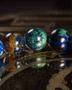 Detalle macro de cuentas de Crisocola verde y azul sobre superficie grabada
