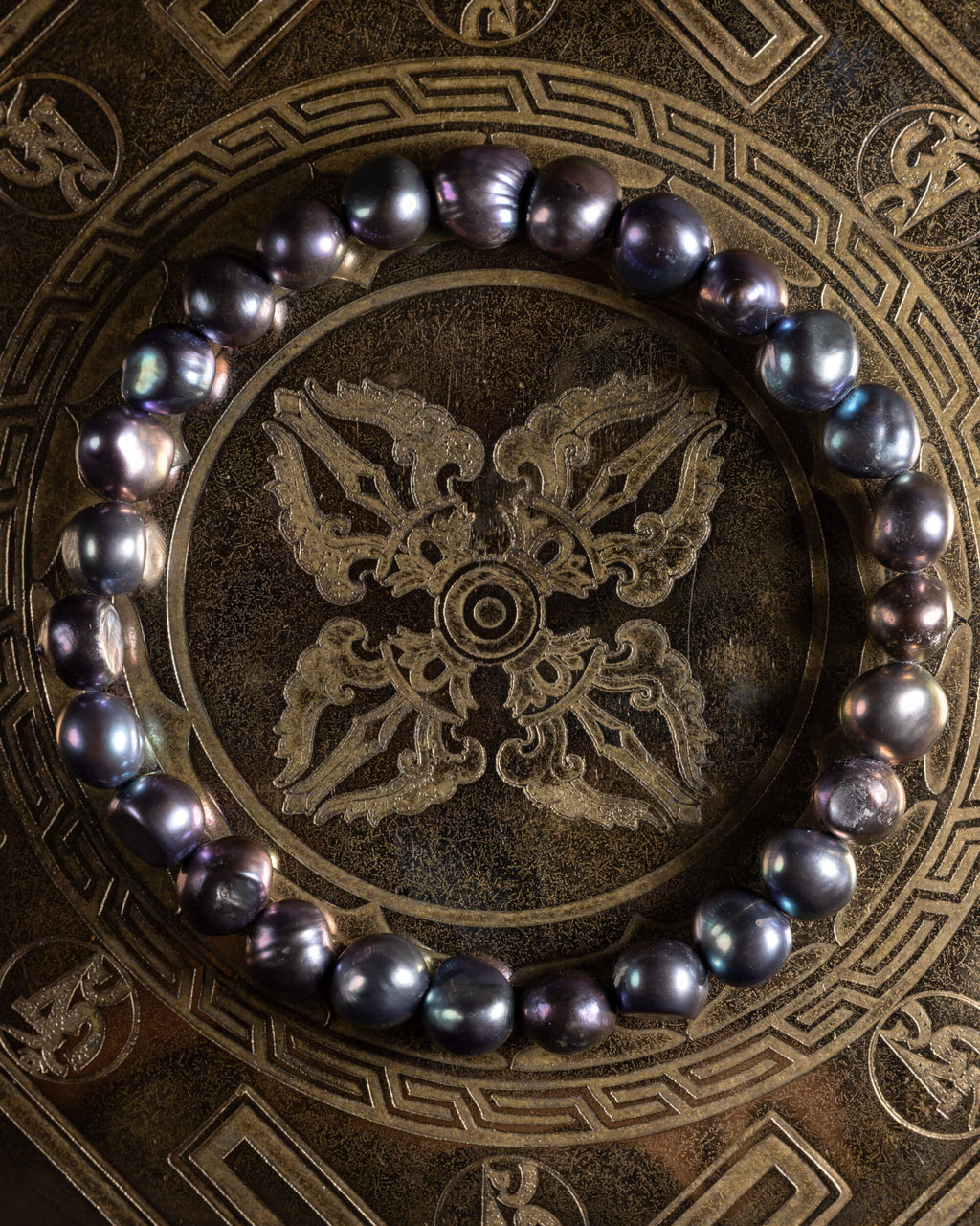 Pulsera de Perla Negra, pieza completa en círculo sobre disco grabado