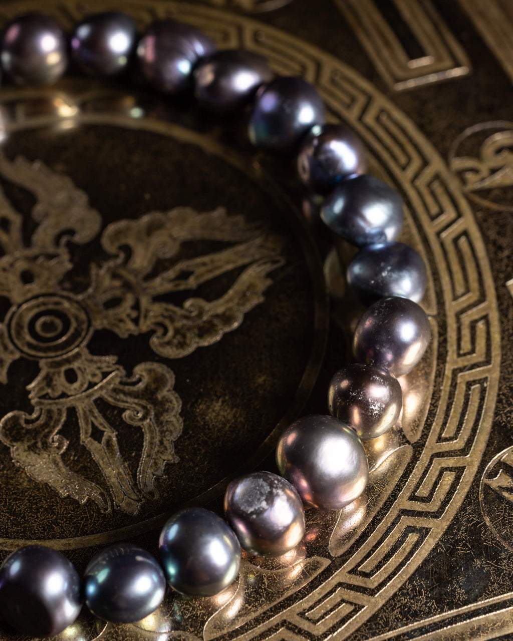Pulsera de Perla Negra vista desde arriba, curva sobre disco grabado