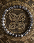 Pulsera de Larvikita de 6 mm, pieza completa en círculo sobre placa grabada dorada