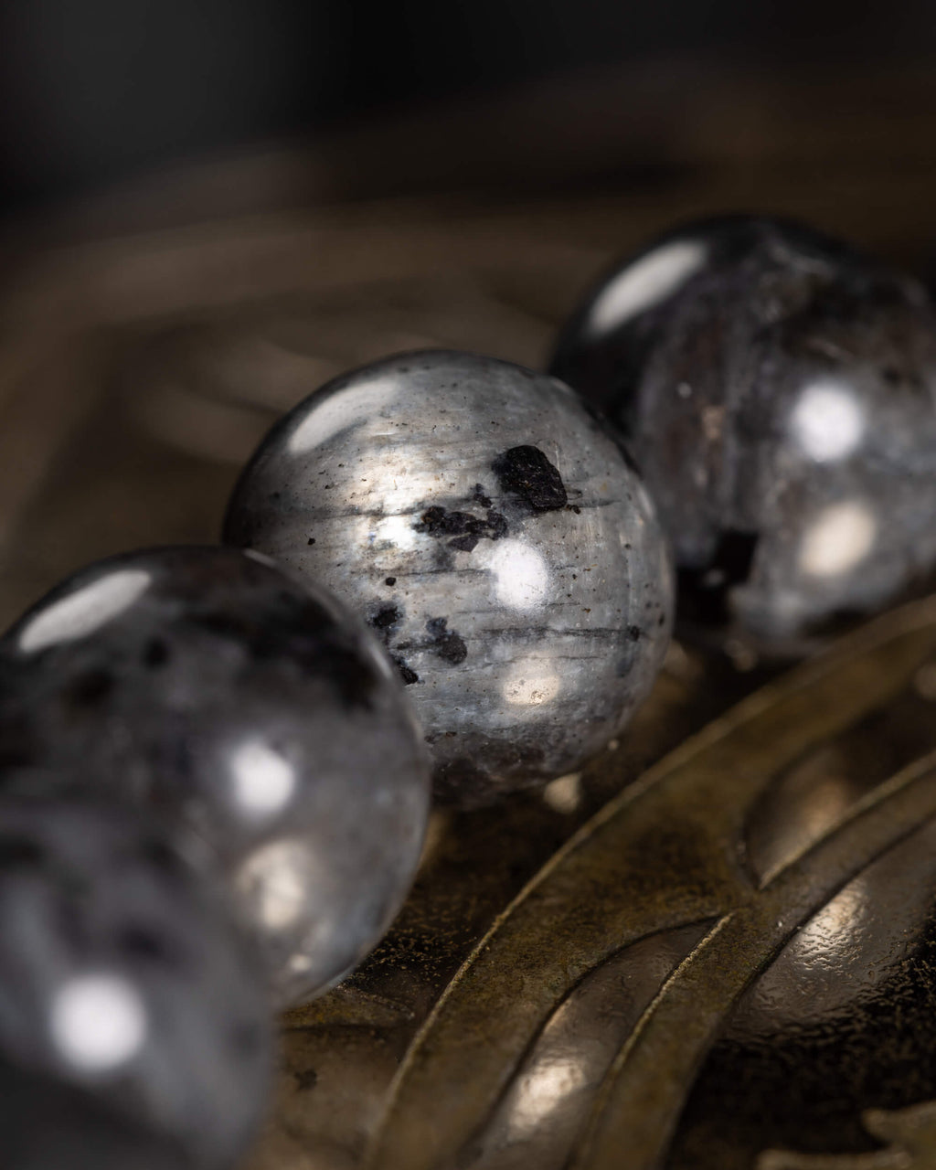 Detalle macro cercano de una cuenta de Larvikita con vetas y moteado