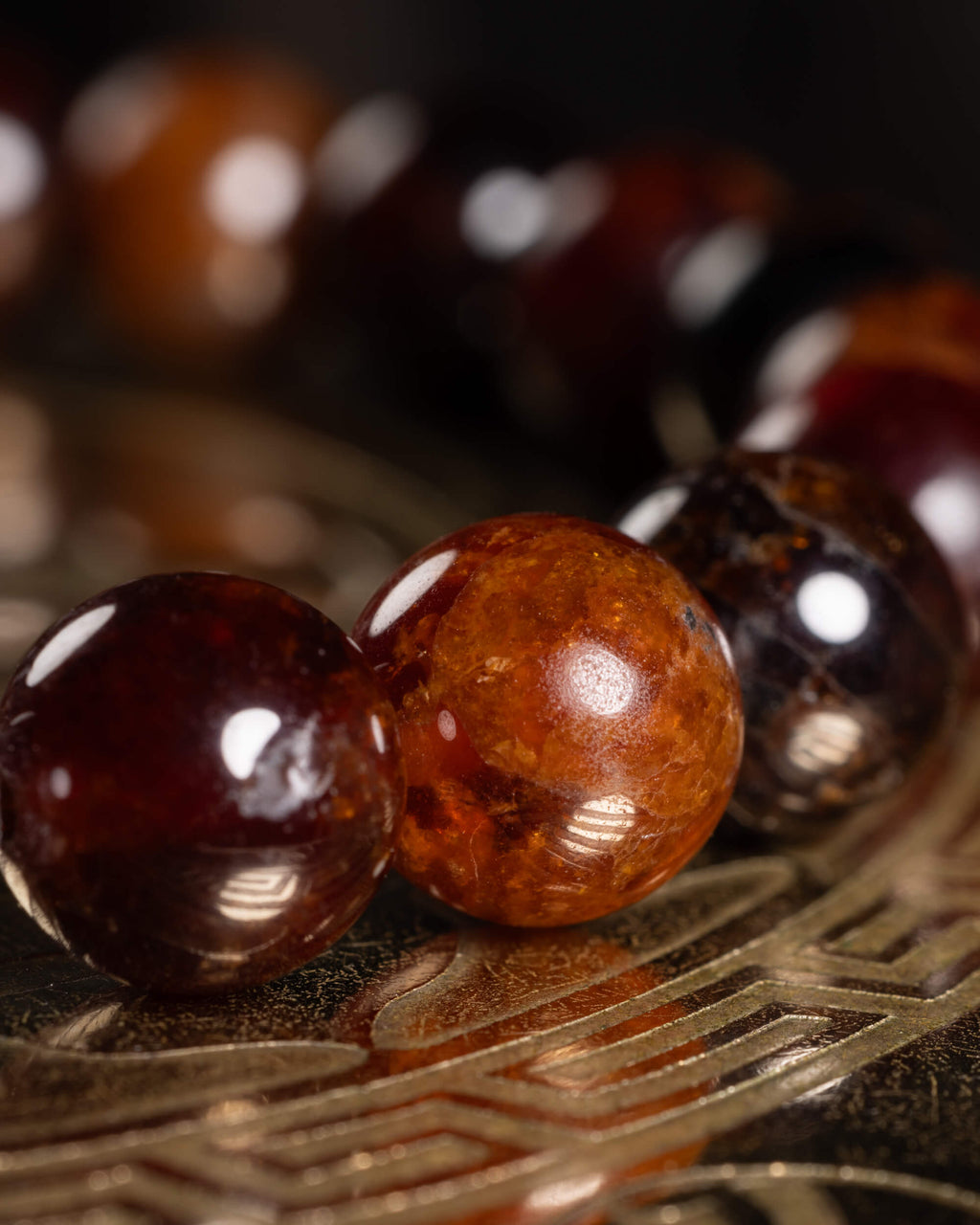 Detalle macro de las cuentas de Granate Espesartina en tonos naranja y vino