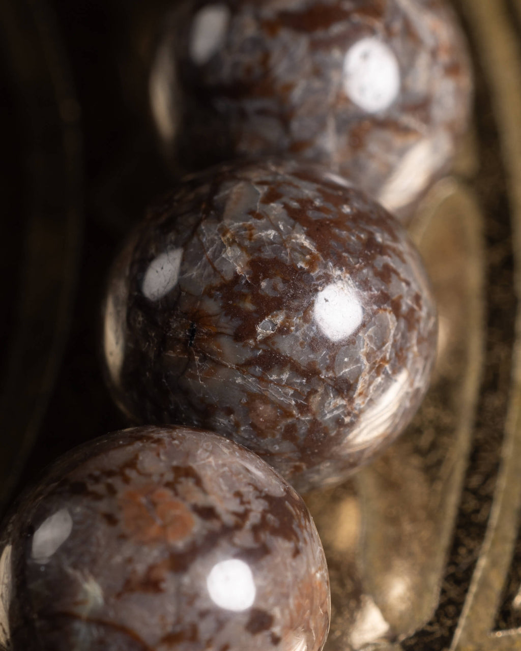 Detalle macro de tres cuentas de Obsidiana Copo de Nieve Café con vetas naturales