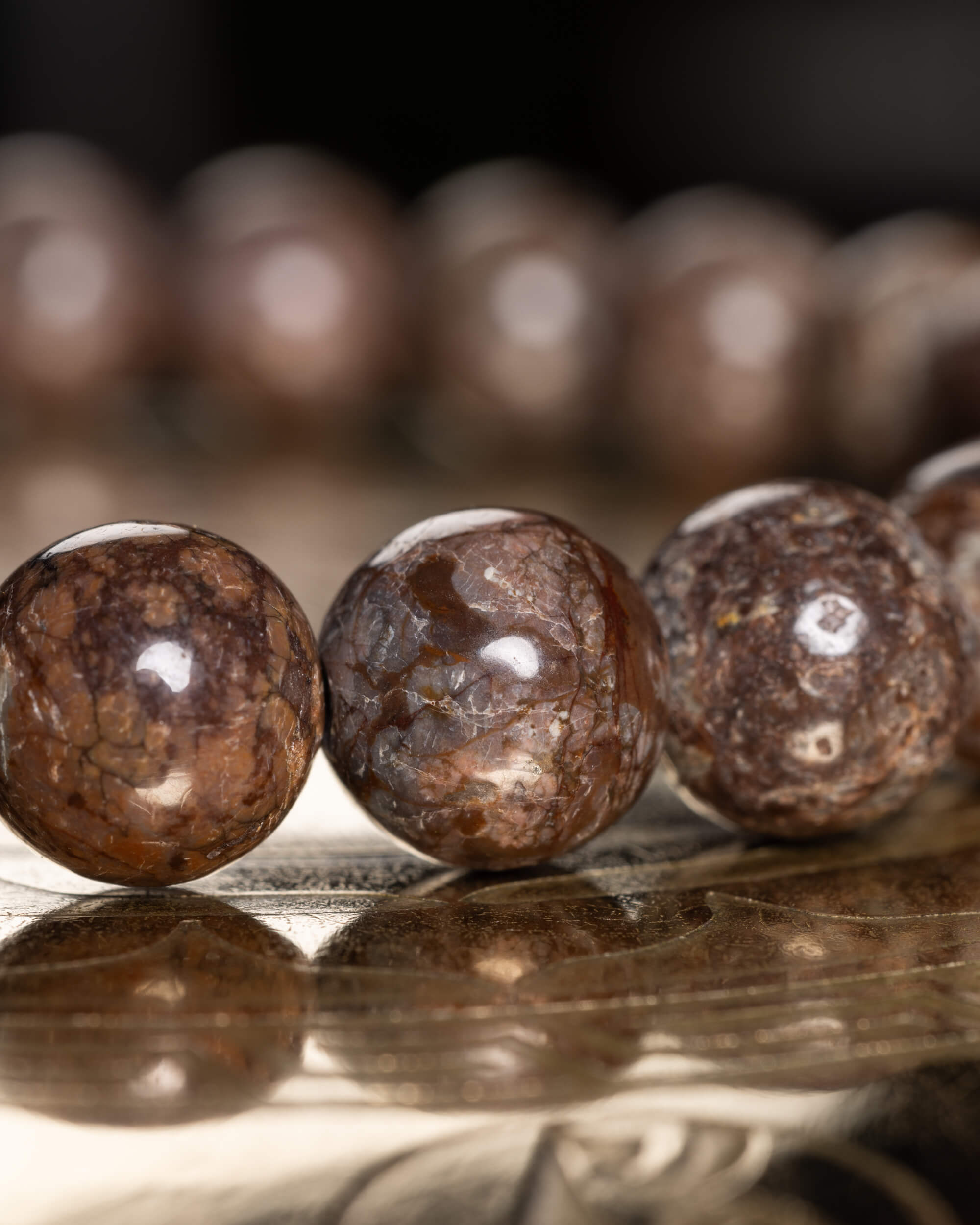 Pulsera de Obsidiana Copo de Nieve Café con reflejo de las cuentas sobre la bandeja