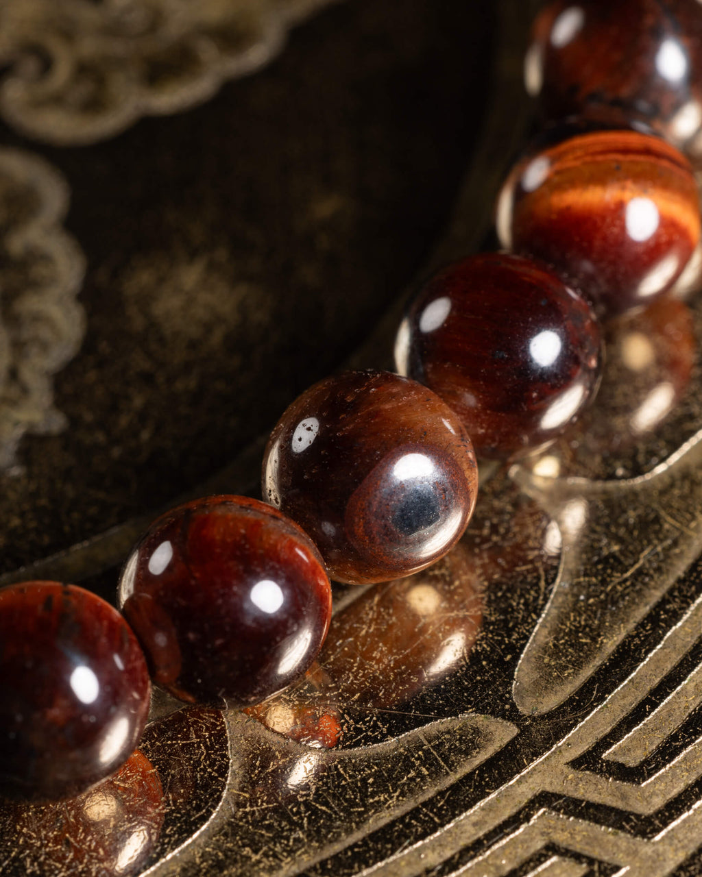 Detalle macro de las cuentas de Ojo de Tigre Rojo, tonos cobrizos y oscuros