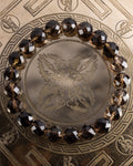 Pulsera de Cuarzo Ahumado facetado de 10 mm, pieza completa sobre soporte grabado
