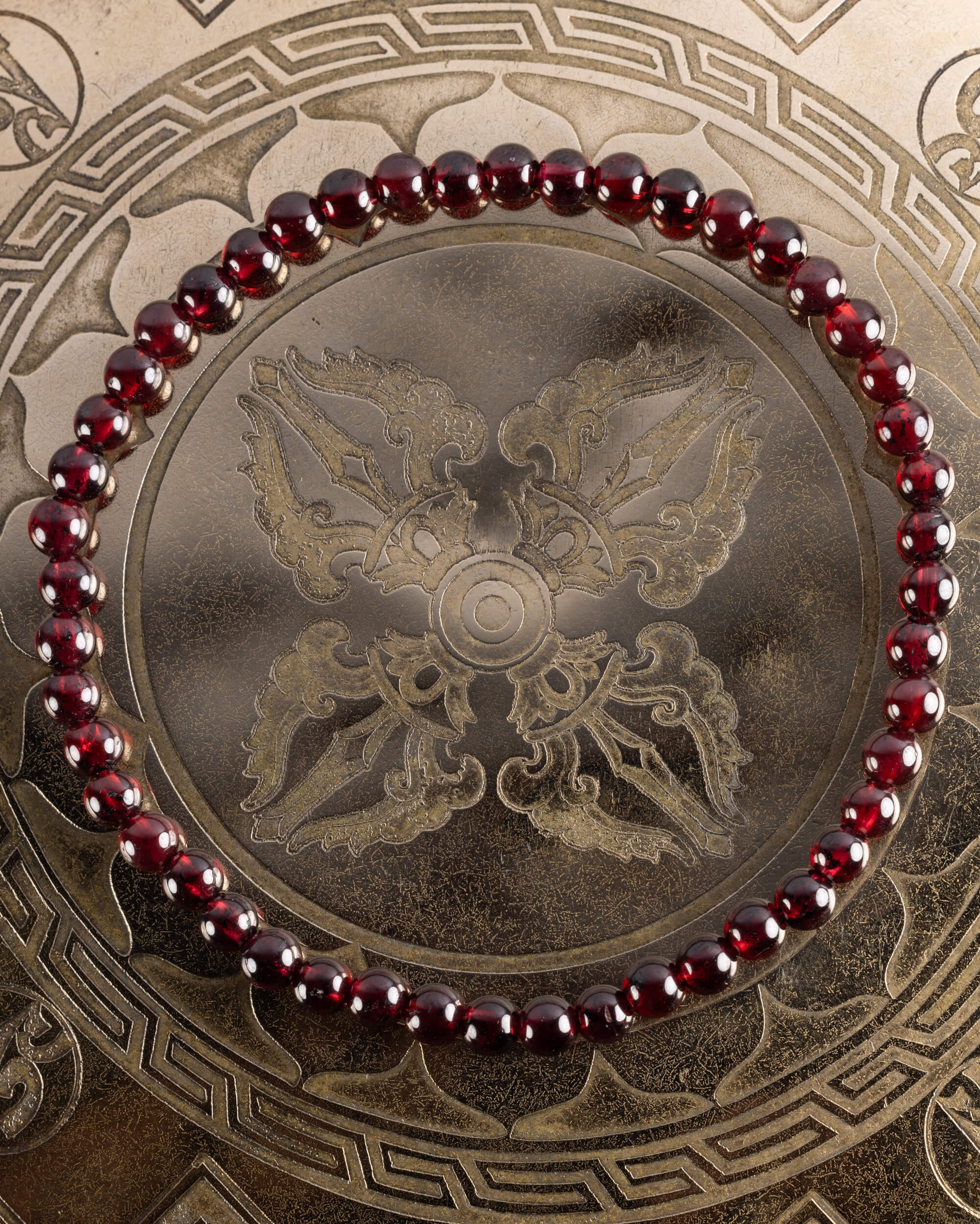 Pulsera de Granate Rojo de 4 mm, pieza completa en círculo sobre placa grabada dorada