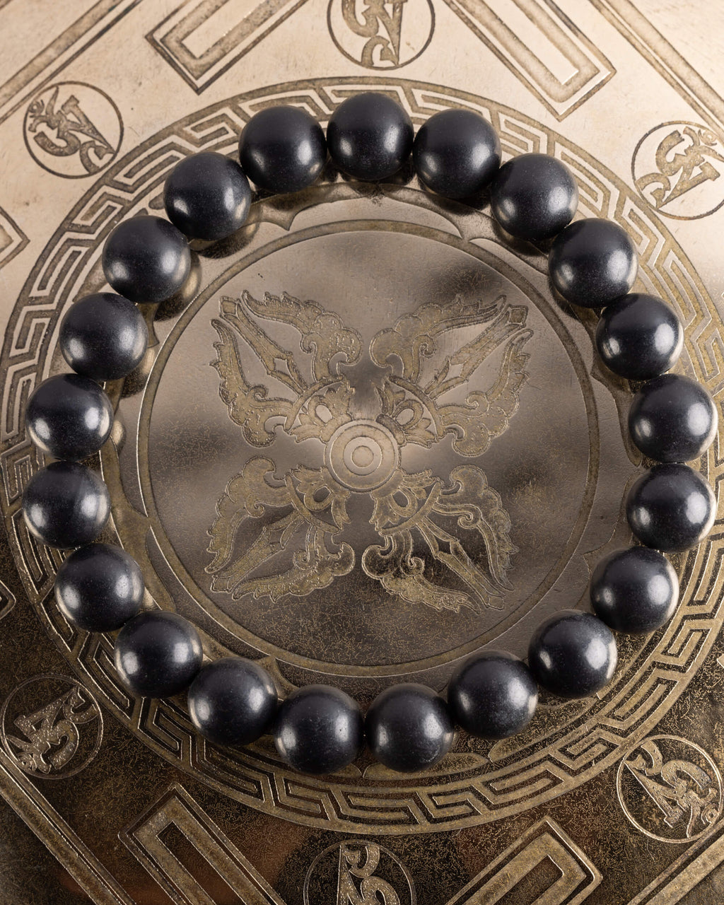 Pulsera de Shungita de 10 mm, pieza completa en círculo sobre plato grabado
