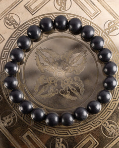 Pulsera de Shungita de 10 mm, pieza completa en círculo sobre plato grabado