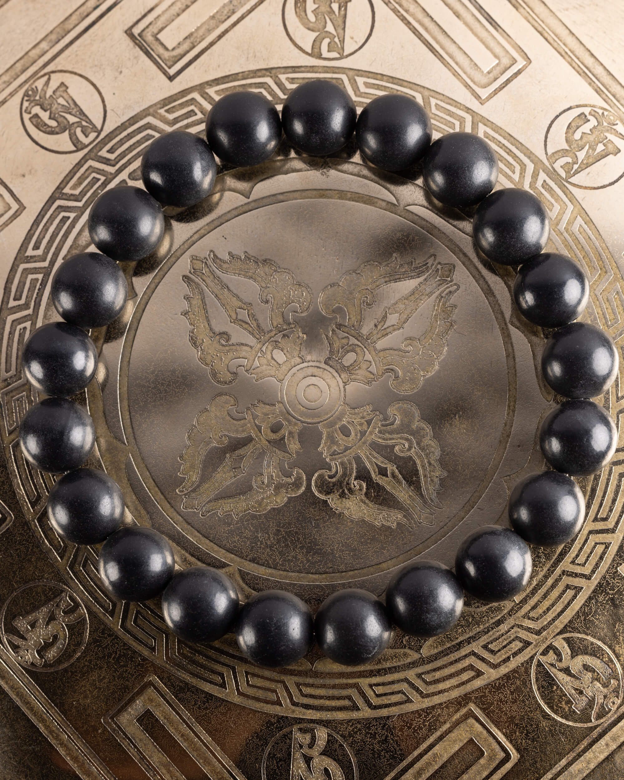 Pulsera de Shungita de 10 mm, pieza completa en círculo sobre plato grabado