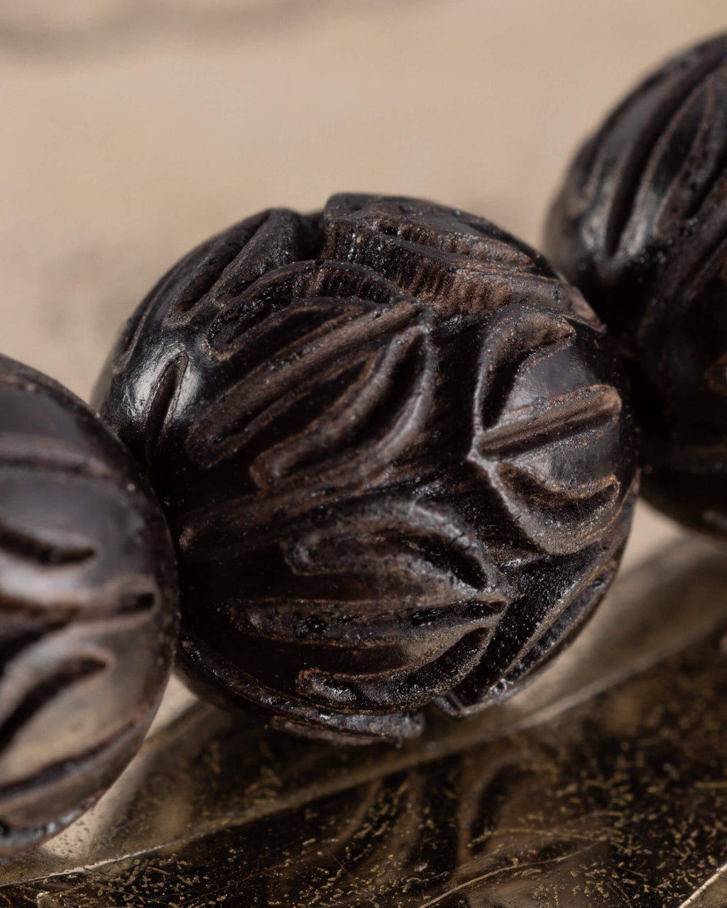 Detalle macro del tallado de flor de loto en las cuentas de Madera de Ebano