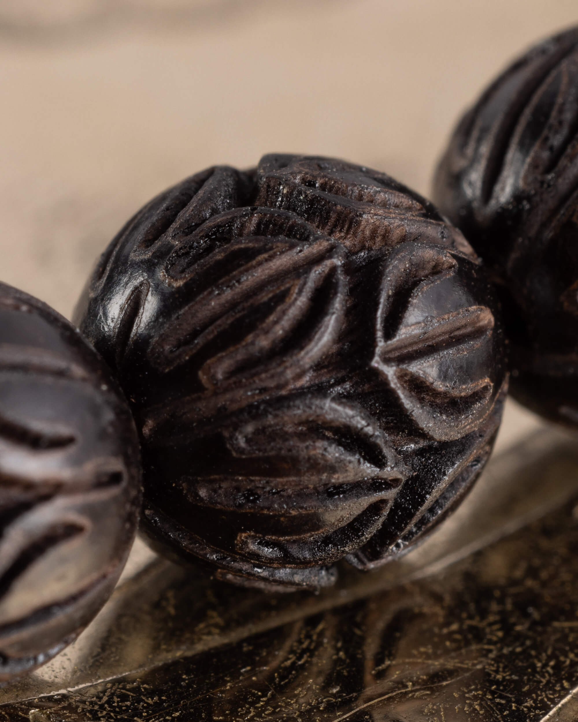 Detalle macro del tallado de flor de loto en las cuentas de Madera de Ebano