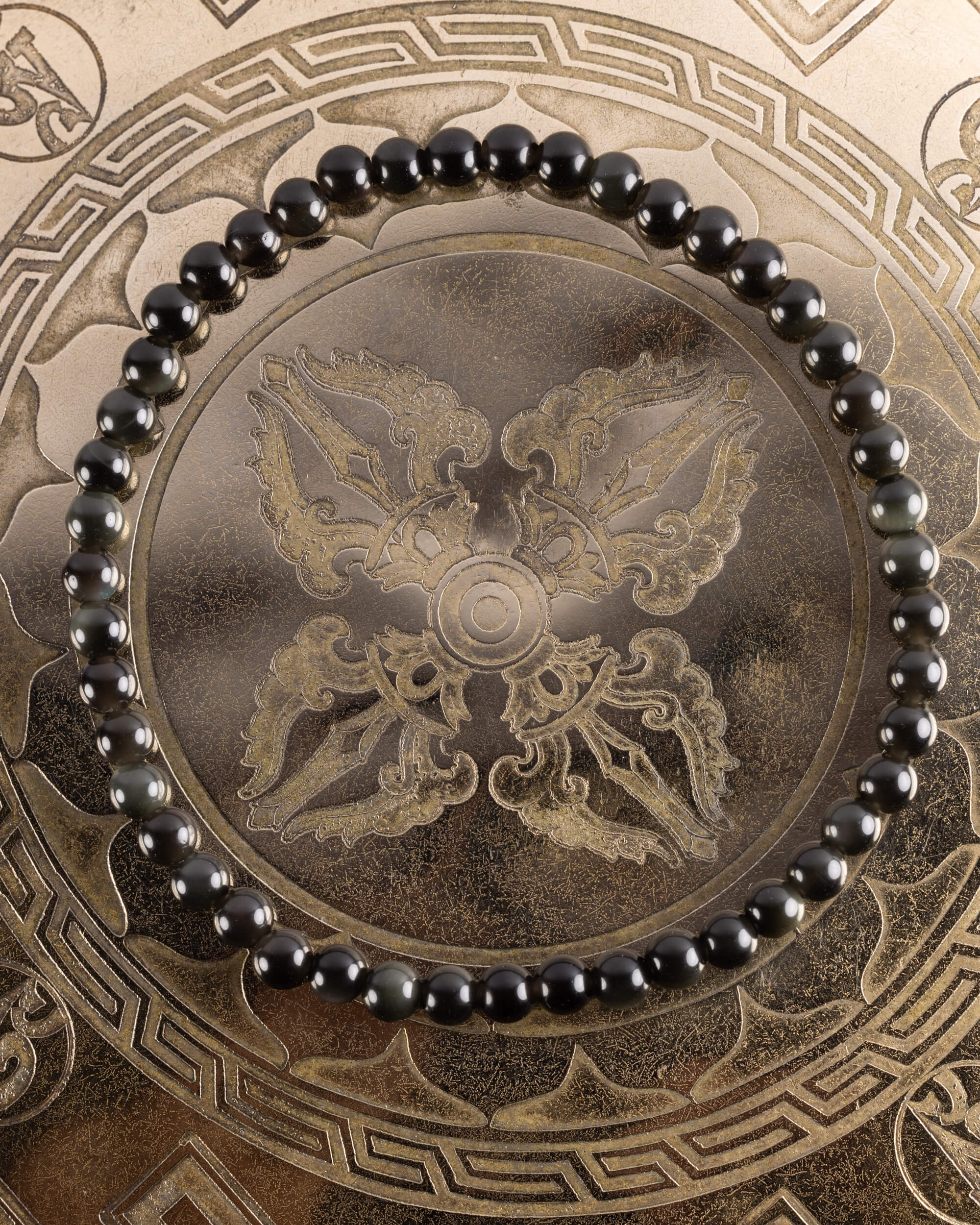 Pulsera de Obsidiana Negra de 4 mm, pieza completa en círculo sobre bandeja grabada