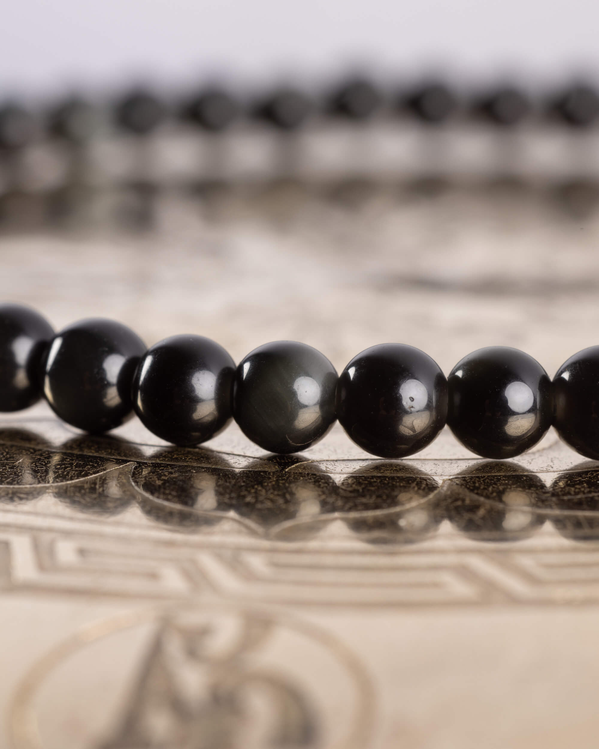 Detalle macro de las cuentas pequeñas de Obsidiana Negra en fila