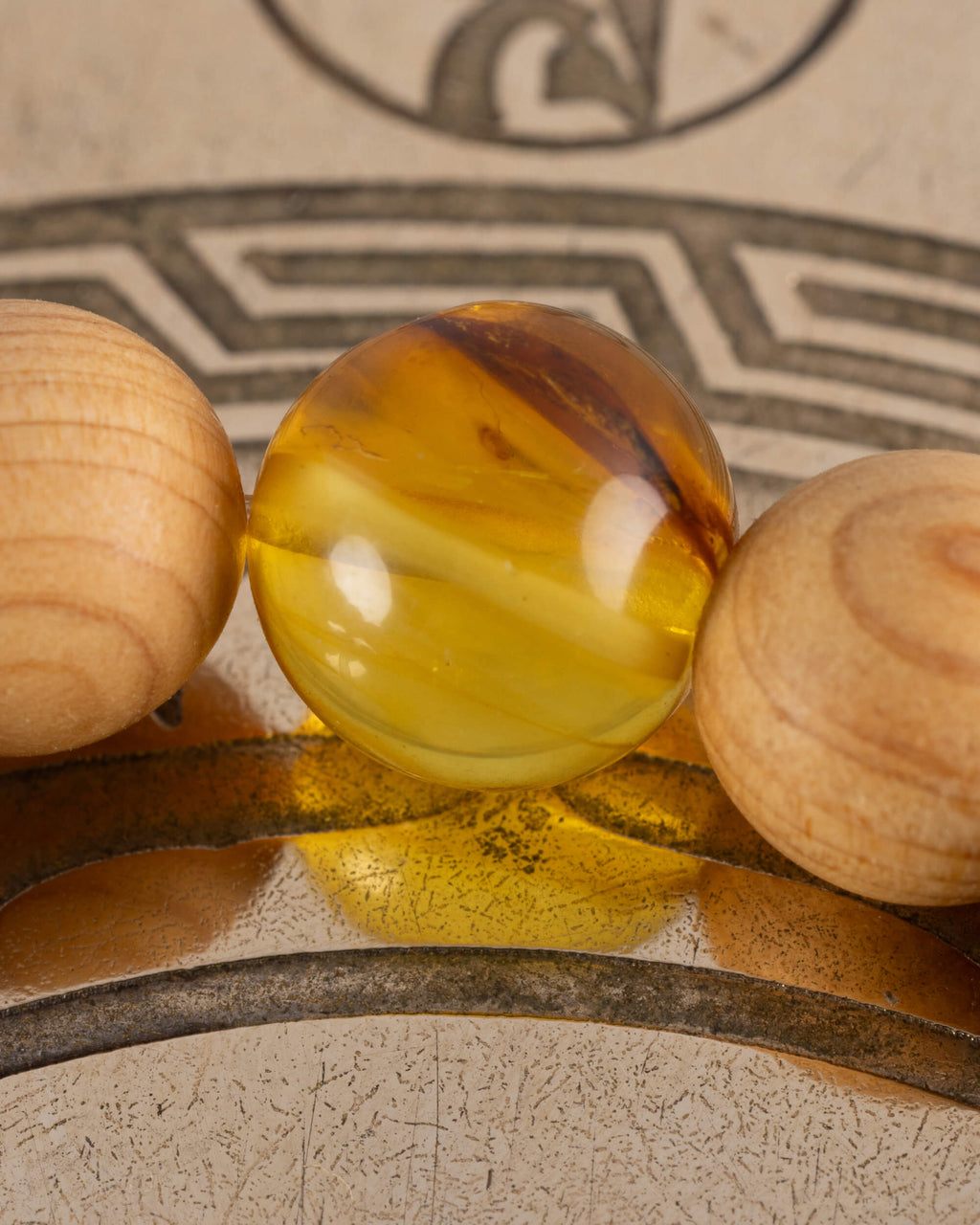 Macro de una cuenta de Ámbar entre esferas de Madera de Sándalo