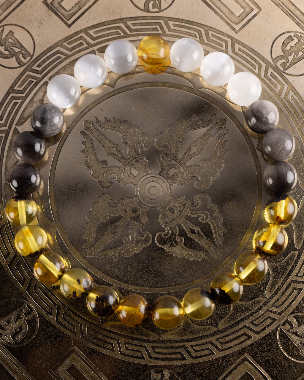 Pulsera Amaterasu de Selenita, Obsidiana Plateada y Ámbar, pieza completa sobre disco grabado