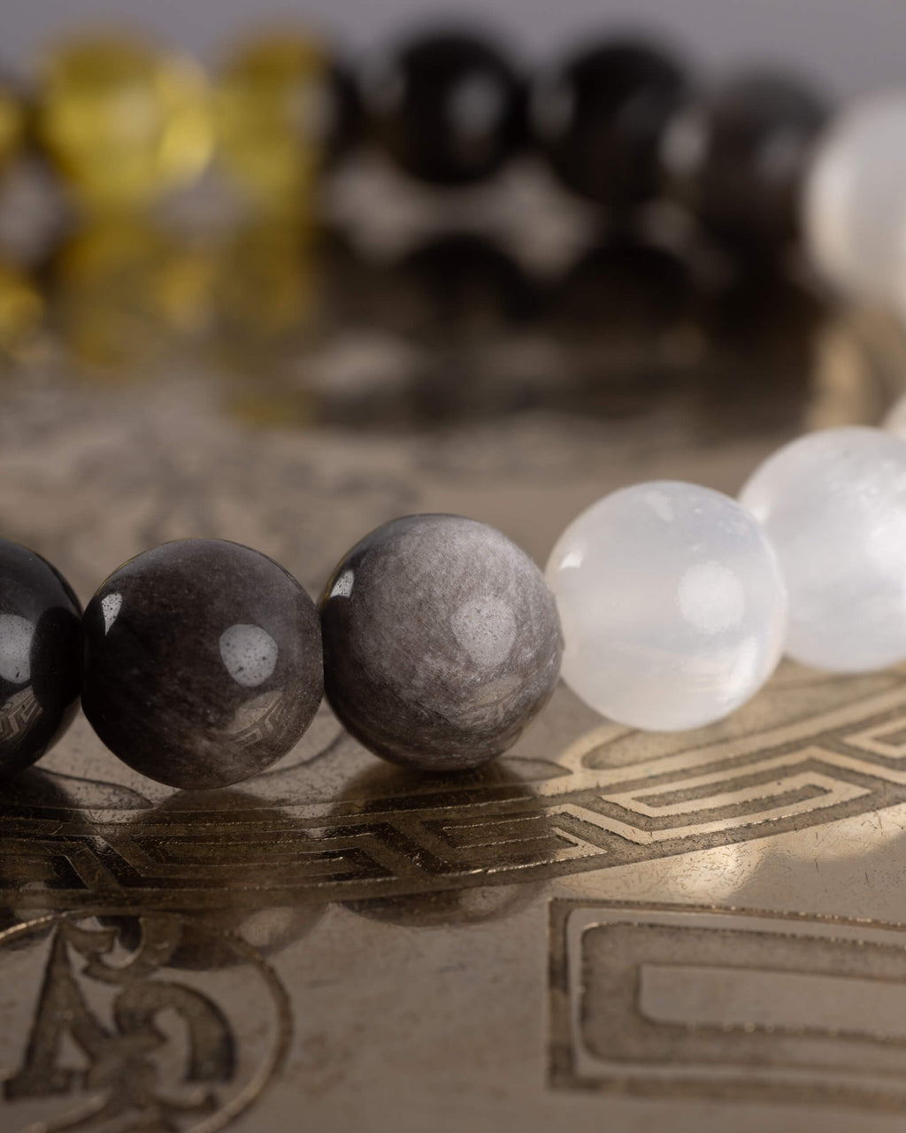 Detalle macro de las cuentas de Obsidiana Plateada y Selenita blanca