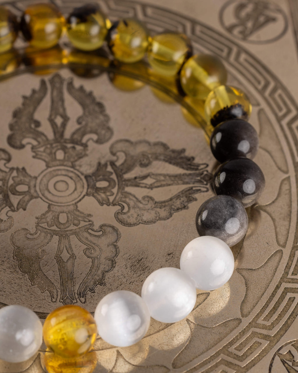 Detalle macro del recorrido de Ámbar, Obsidiana y Selenita de la pulsera Amaterasu