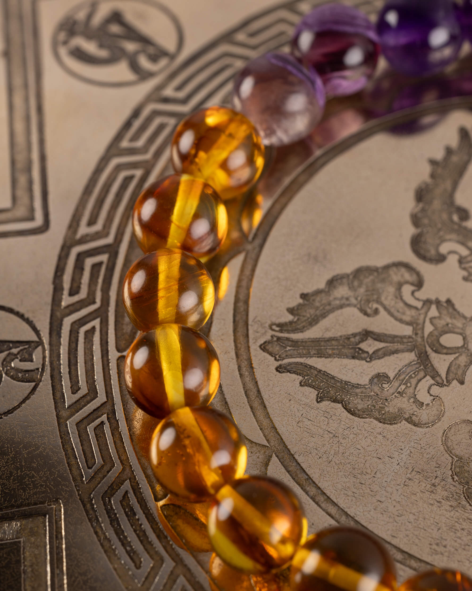 Detalle macro de las cuentas de Ámbar de la pulsera Apolo sobre disco grabado