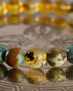 Detalle macro de una cuenta de Ámbar entre Turquesa de la pulsera Huitzilopochtli