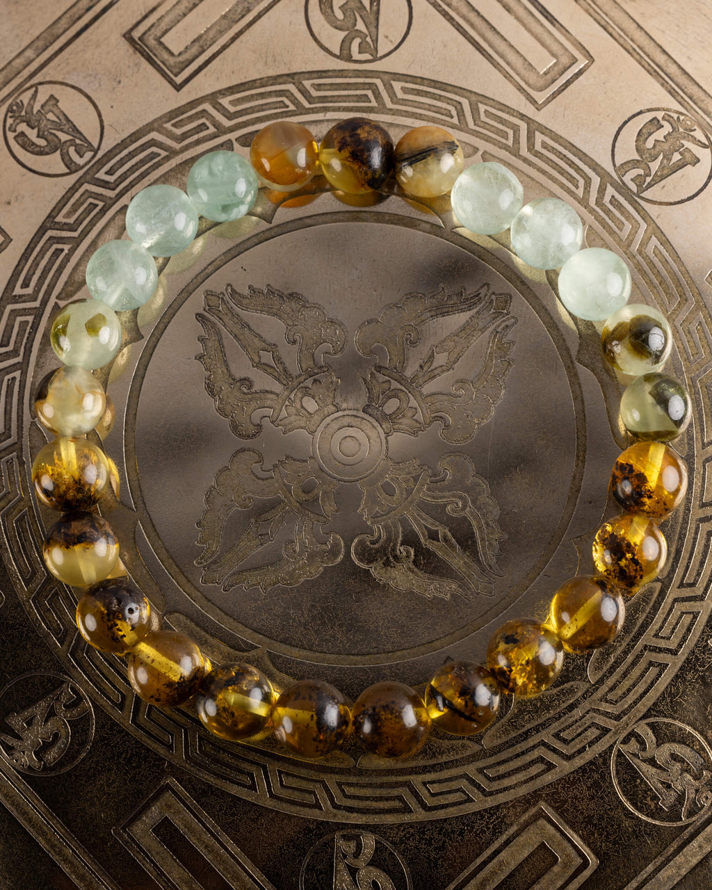 Pulsera Surya de Fluorita, Prehnita y Ámbar, pieza completa sobre disco grabado
