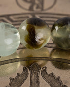 Detalle macro de cuentas verdes palidas y translucidas de Fluorita en la pulsera Surya, fondo borroso