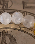 Detalle macro de tres cuentas de Piedra Luna sobre disco grabado