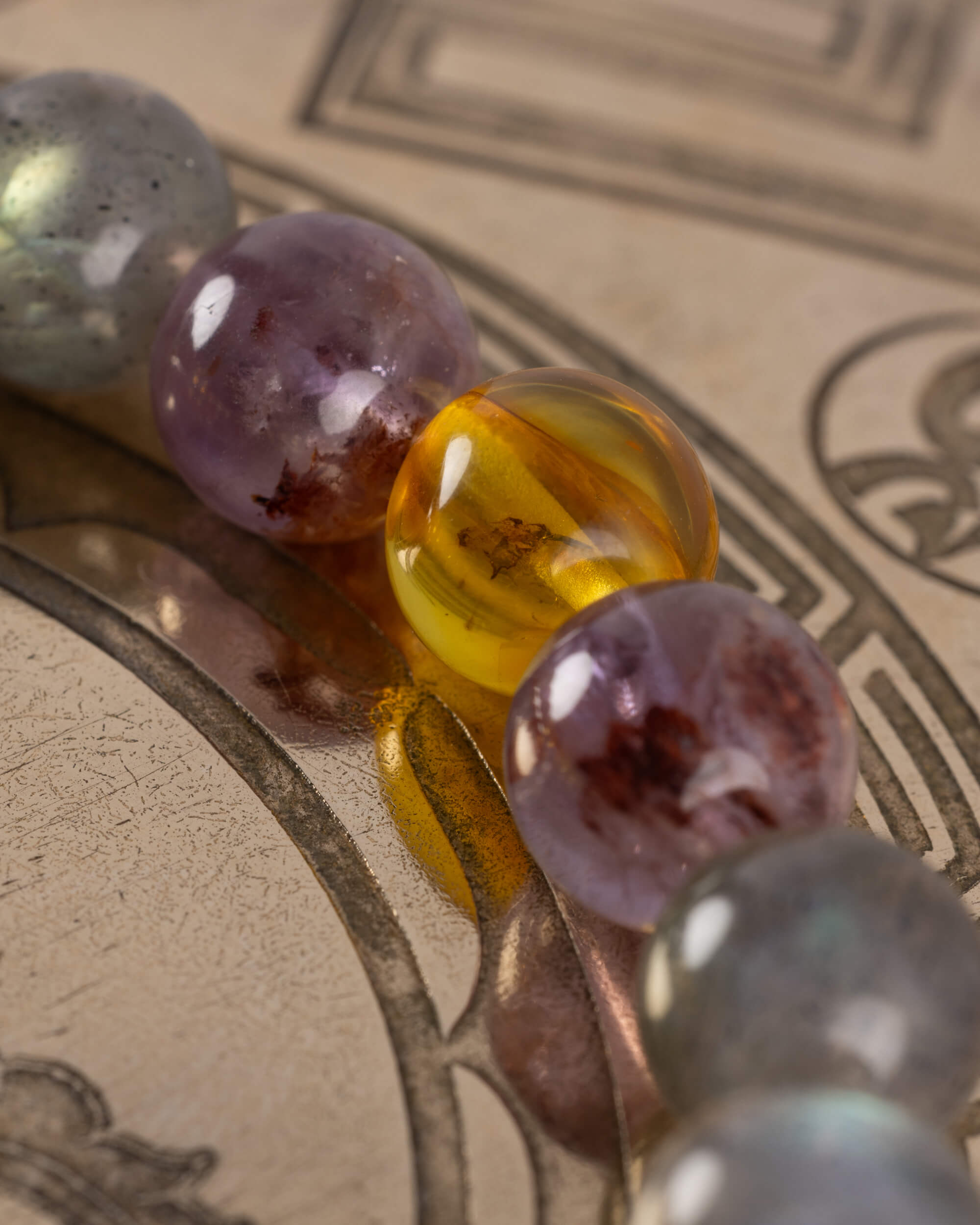 Detalle macro de las cuentas de Amatista Fantasma y Ámbar de la pulsera Mithra