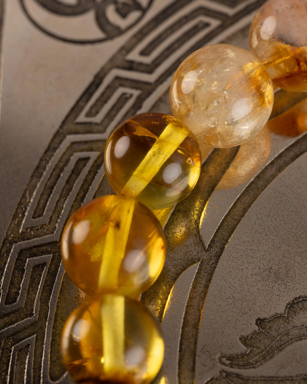Detalle macro de las cuentas de Ámbar de la pulsera Sol Invictus con inclusiones naturales