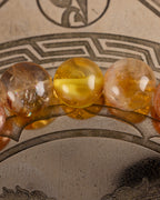 Detalle macro de cuentas de Citrino junto a una cuenta de Ámbar de la pulsera Sol Invictus